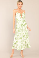 Front view of a green floral dress featuring a sweetheart neckline, and a self-tie ring detailing at the center of the bust.
