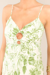 Close up view of this green floral print dress features a sweetheart neckline, and a self-tie ring detailing at the center of the bust.