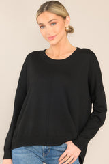 Front view of  this sweater that features a round, ribbed neckline, a seam going down the center, and a ribbed hem and cuffs.