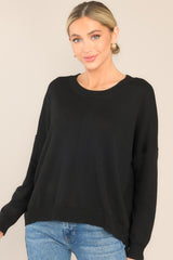 Full front view of  this sweater that features a round, ribbed neckline, a seam going down the center, and a ribbed hem and cuffs.