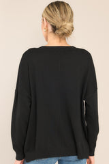 Back view of  this sweater that features a round, ribbed neckline, a seam going down the center, and a ribbed hem and cuffs.
