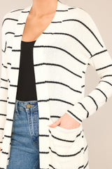Close up view of this cardigan that features an open-front design, a soft-knit fabric, functional pockets, and long sleeves.