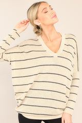 Front view of this top that features a v-neckline, mid-length sleeves, striped design, and an oversized fit.