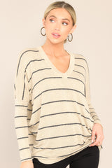 Full front view of this top that features a v-neckline, mid-length sleeves, striped design, and an oversized fit.