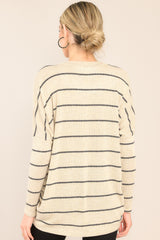 Back view of this top that features a v-neckline, mid-length sleeves, striped design, and an oversized fit.