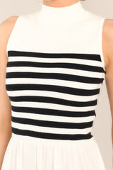 Close up view of this dress that features a high neckline, a striped sweater bodice, and a flowy skirt.