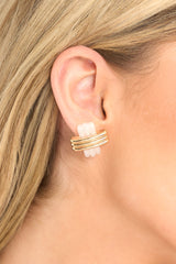 These earrings feature an ivory and gold cross pattern design, and secure post backings. 