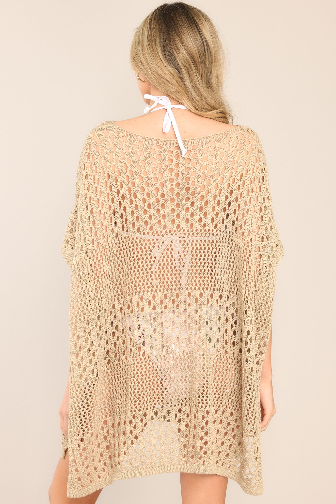 Back view of this cover up that features a v-neckline, dropped shoulders, a chunky knit material, and cuffed sleeves.