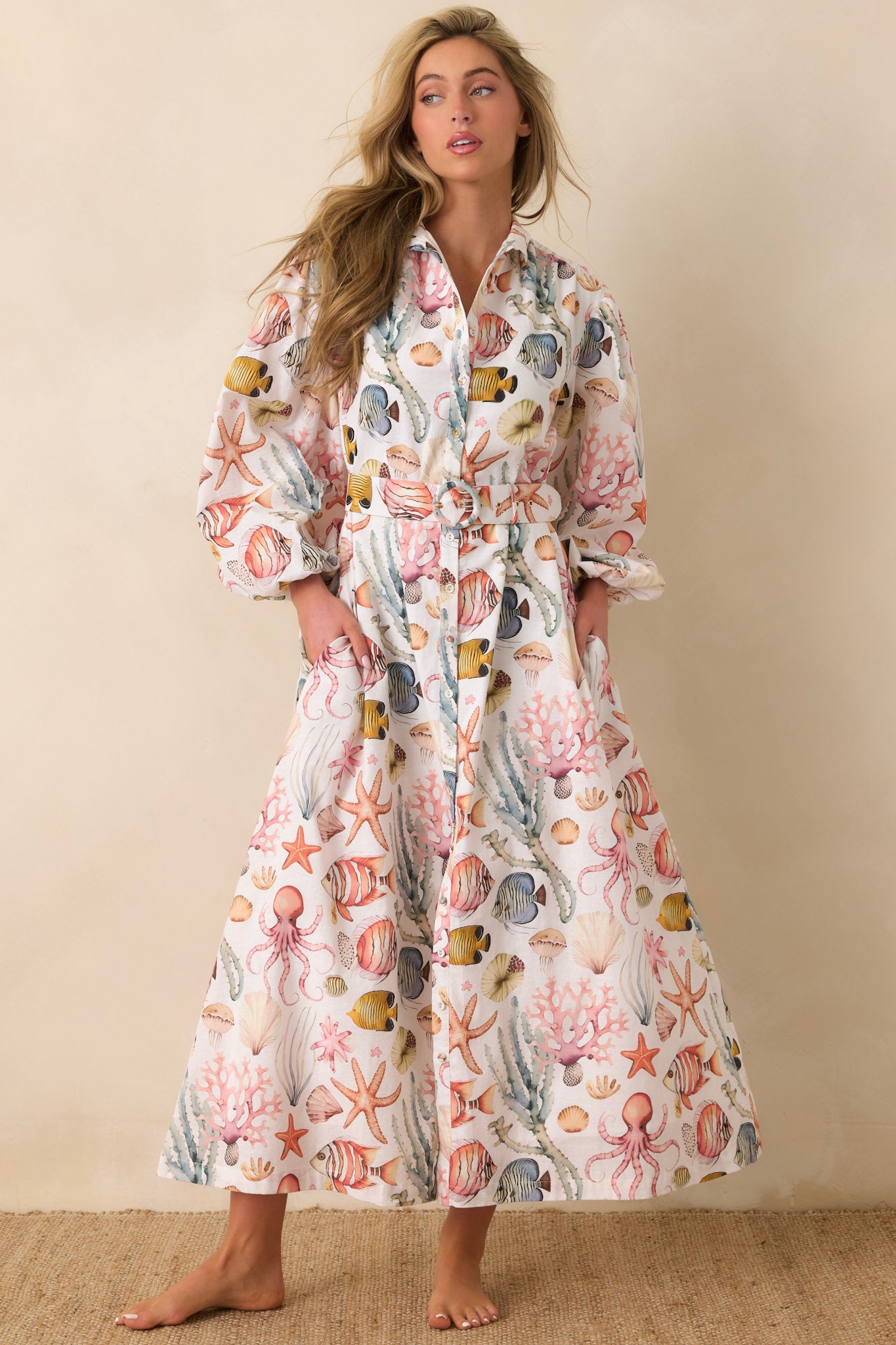 Woman wearing a sea creature maxi dress on a beige background.
