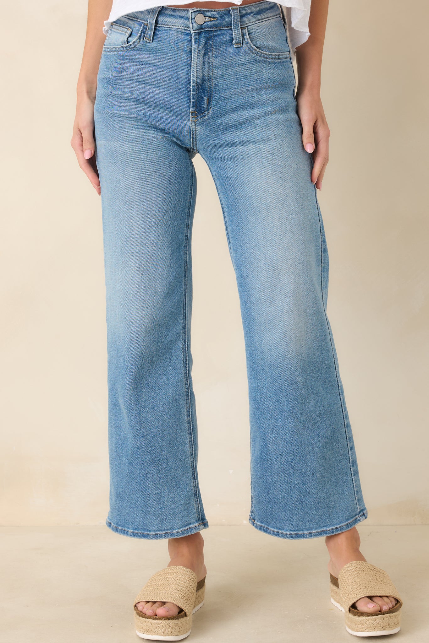 Light wash high-waist jeans with a wide-leg silhouette, slightly cropped length, and functional front and back pockets.