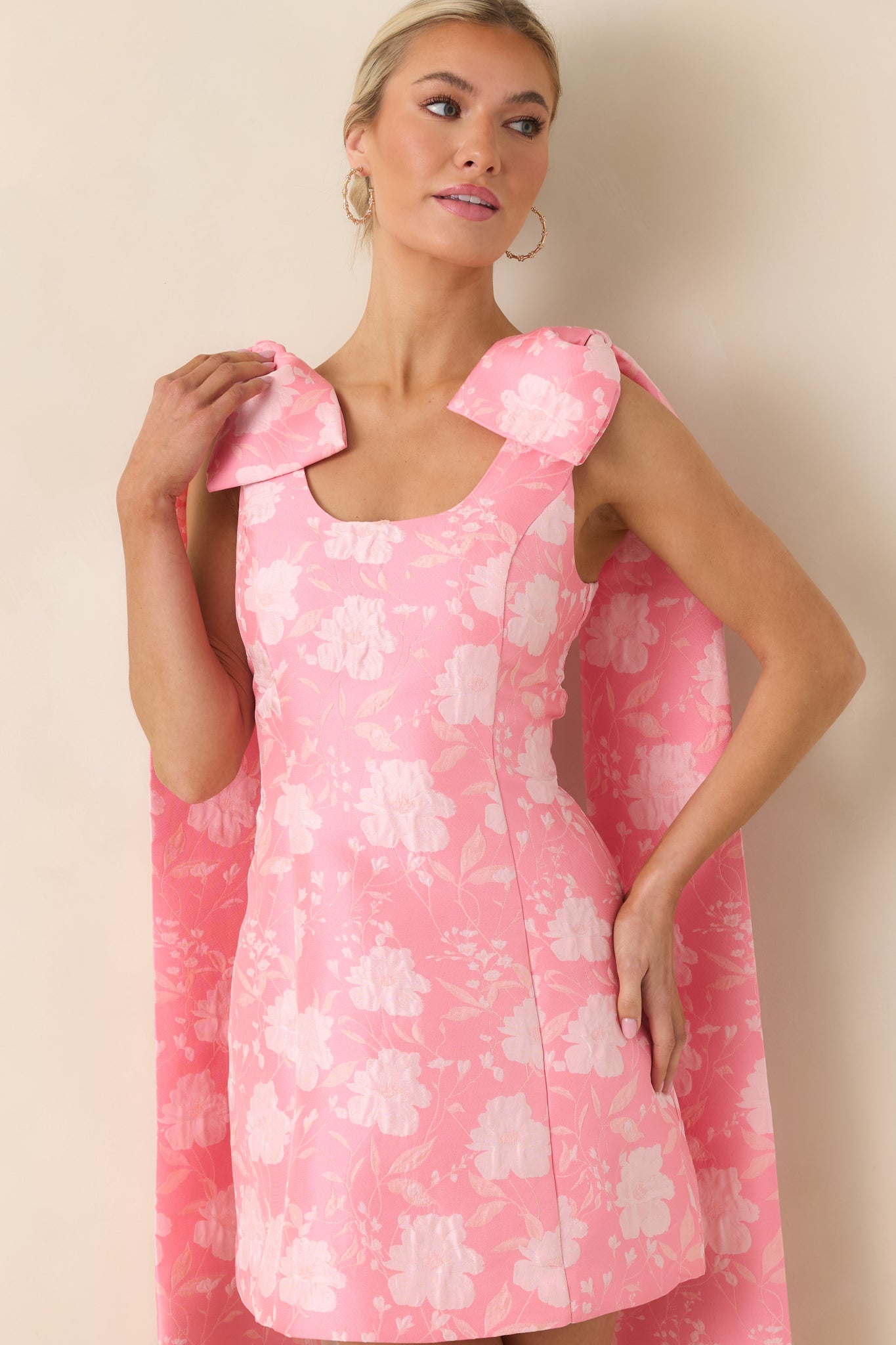 Textured jacquard fabric detail on pink mini dress showing subtle floral pattern and fitted bodice.