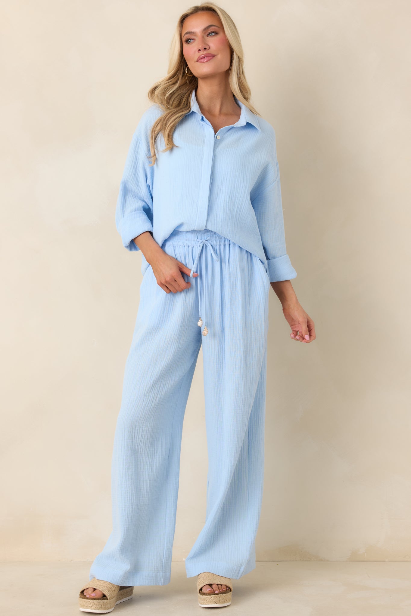 Relaxed silhouette blue cotton shirt with classic collar, front buttons, and versatile high-low hemline.