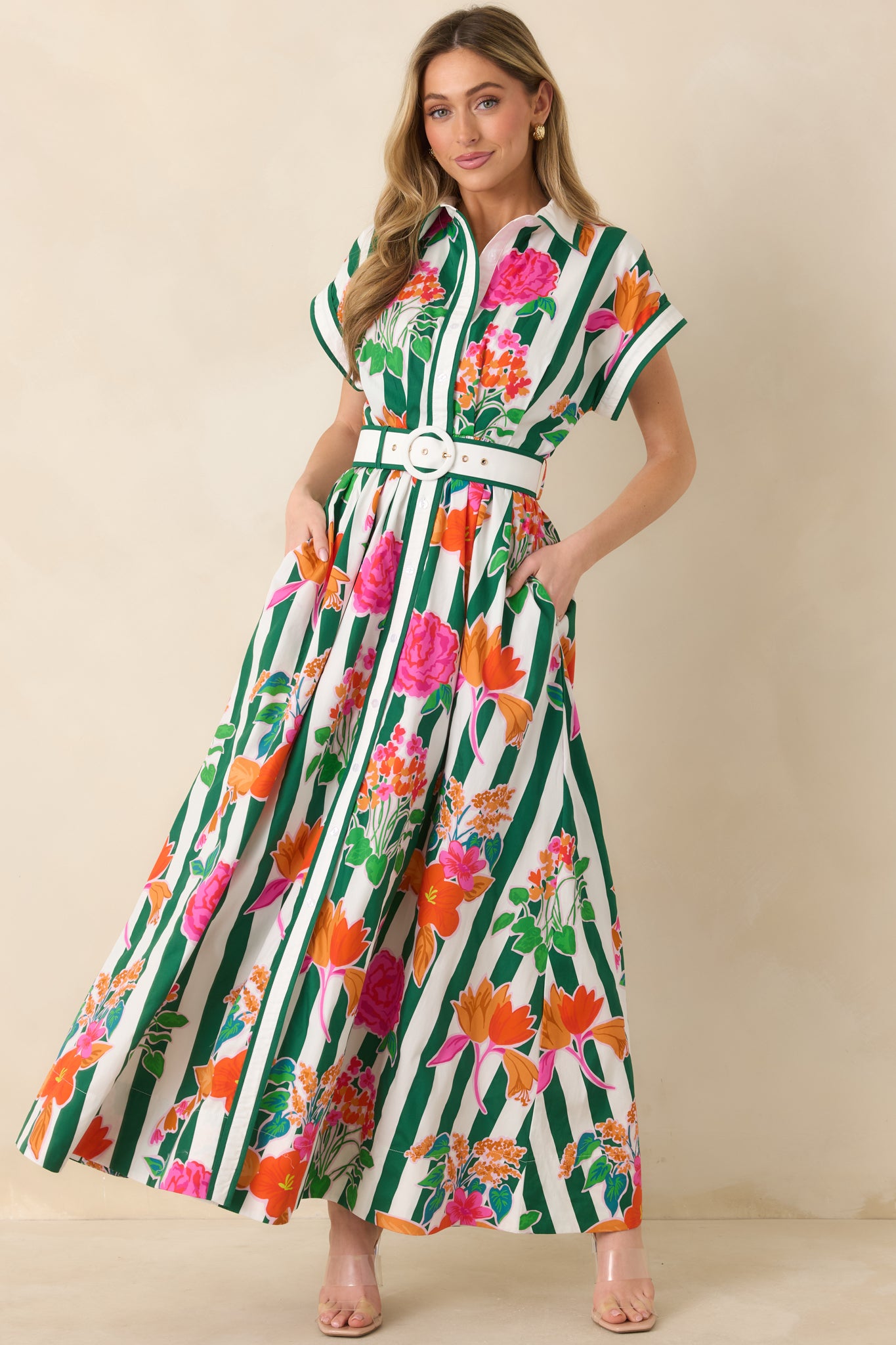 Vibrant cotton maxi dress with mixed floral print and vertical green stripes, short sleeves, and a full-length flowing skirt.