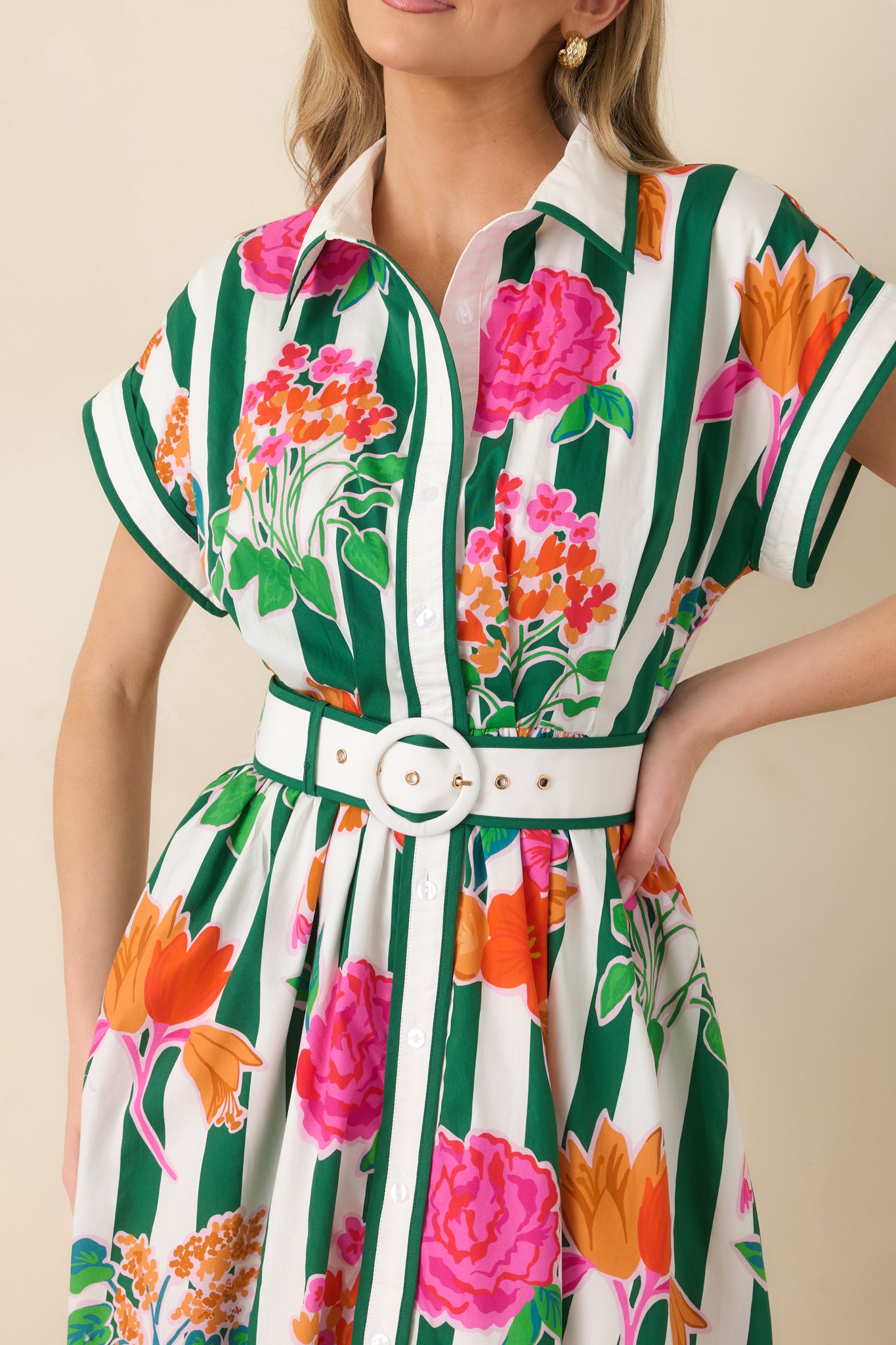 Detailed view of the green striped cotton fabric with pink, orange, and coral floral print, button-front bodice, and cuffed sleeve detail.