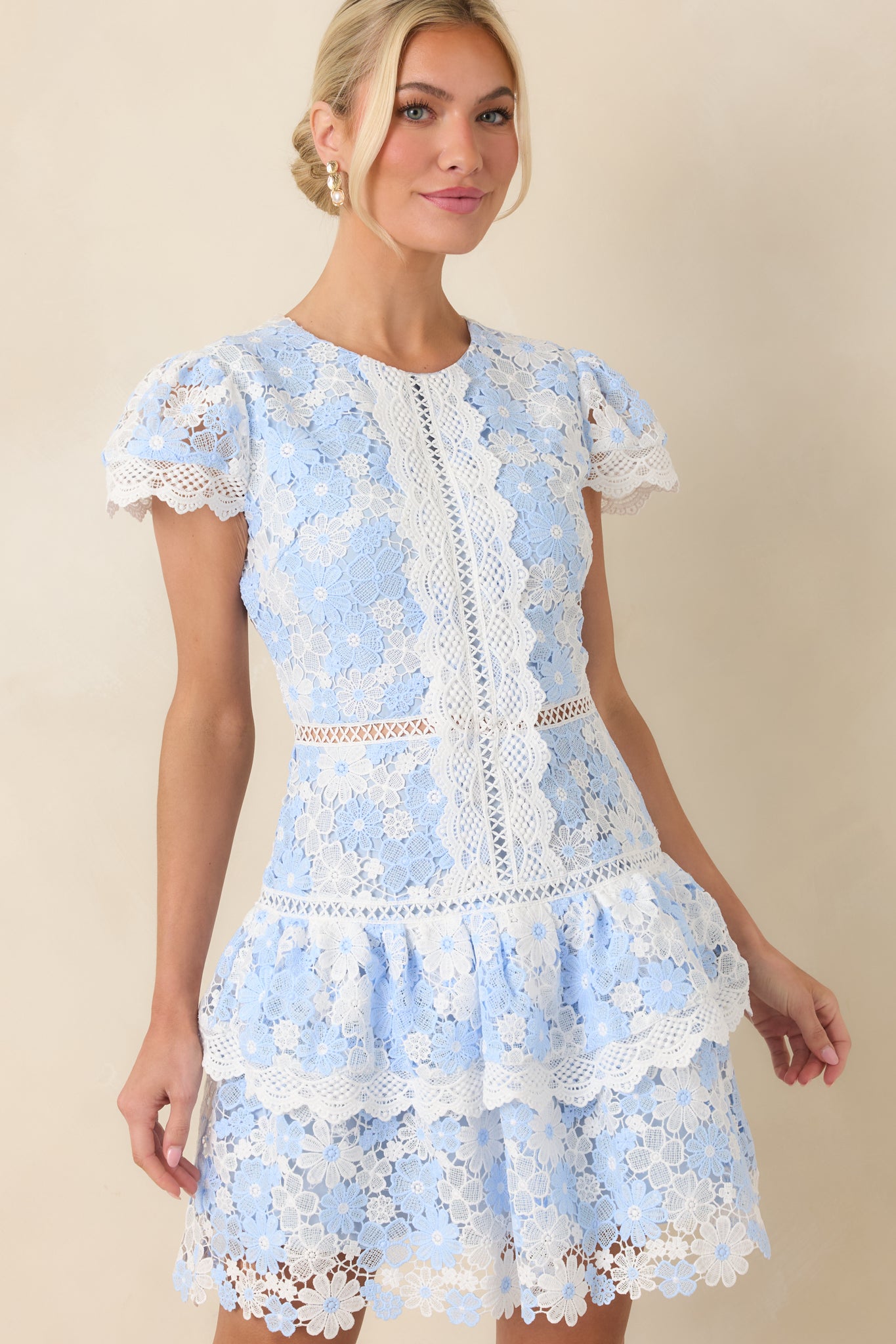Textured lace fabrication featuring blue and ivory florals with fine stitching throughout.