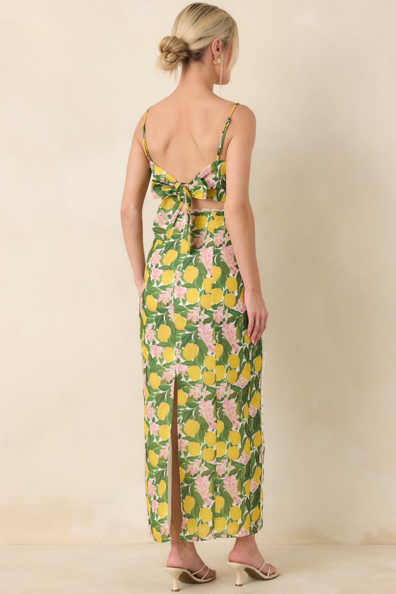 Full-length rear view of the yellow high-rise maxi skirt showcasing the straight silhouette, back slit, and fitted waistband with concealed zipper closure.