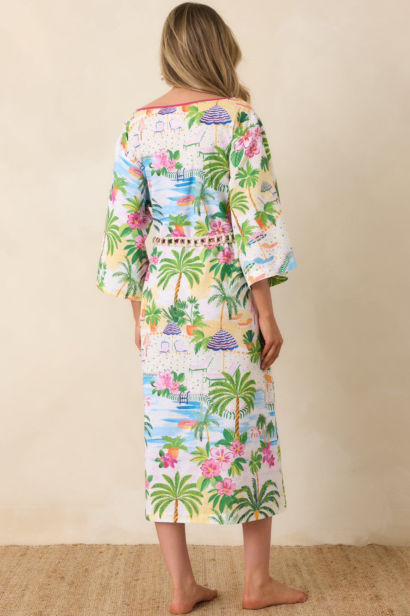 Rear view of the caftan dress with flowy 3/4 sleeves, drawstring waist, and lively poolside print.