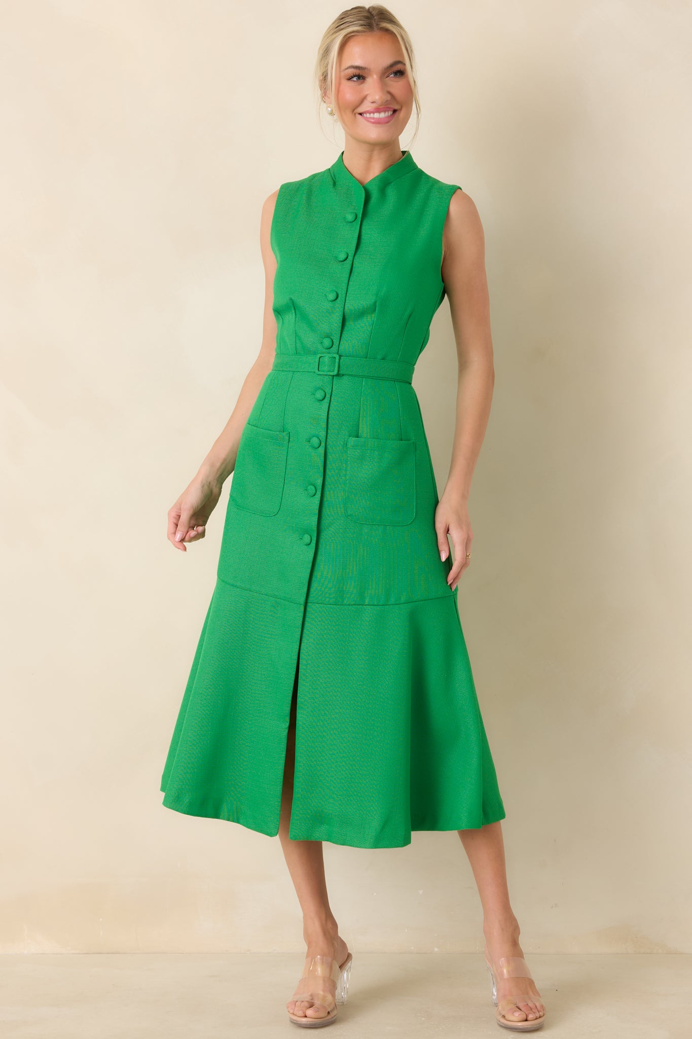 Bright green midi dress designed with a refined stand collar, covered button front, tailored seam accents, functional patch pockets, and a coordinating belt at the waist.
