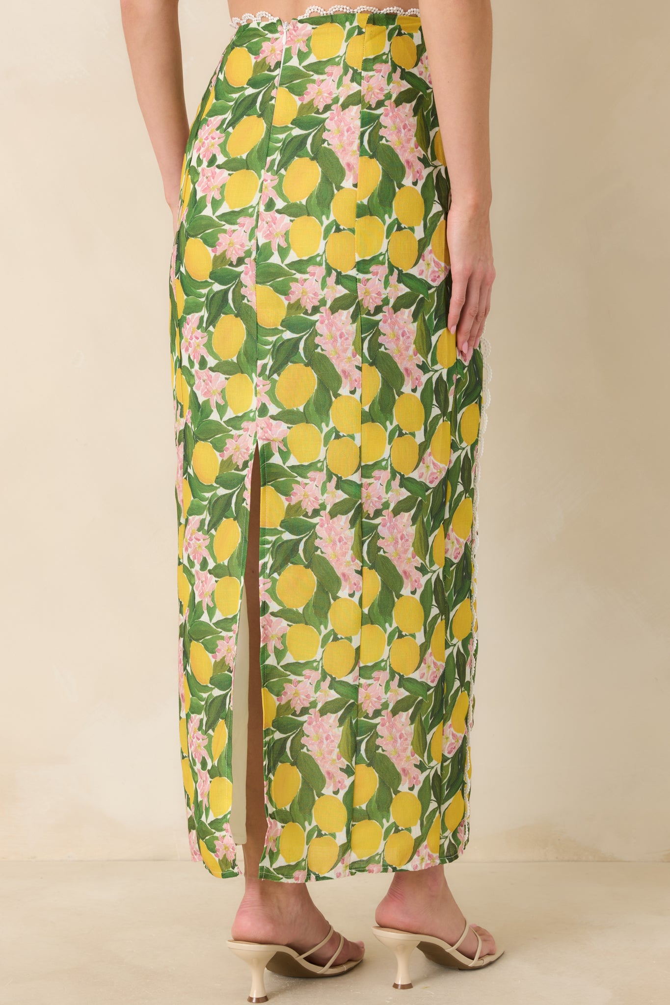 Rear view of the yellow high-rise maxi skirt with a concealed zipper closure and subtle back slit for ease of movement.