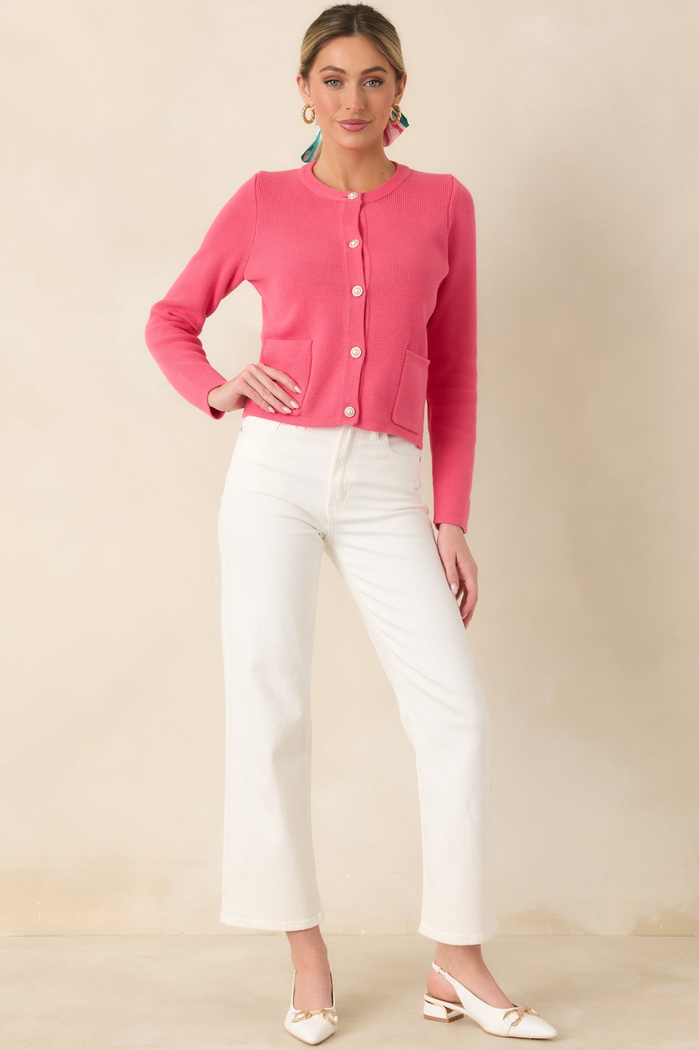Classic knit cardigan crafted from soft cotton with pearl-inspired button closures, a round neckline, and neatly placed front patch pockets.