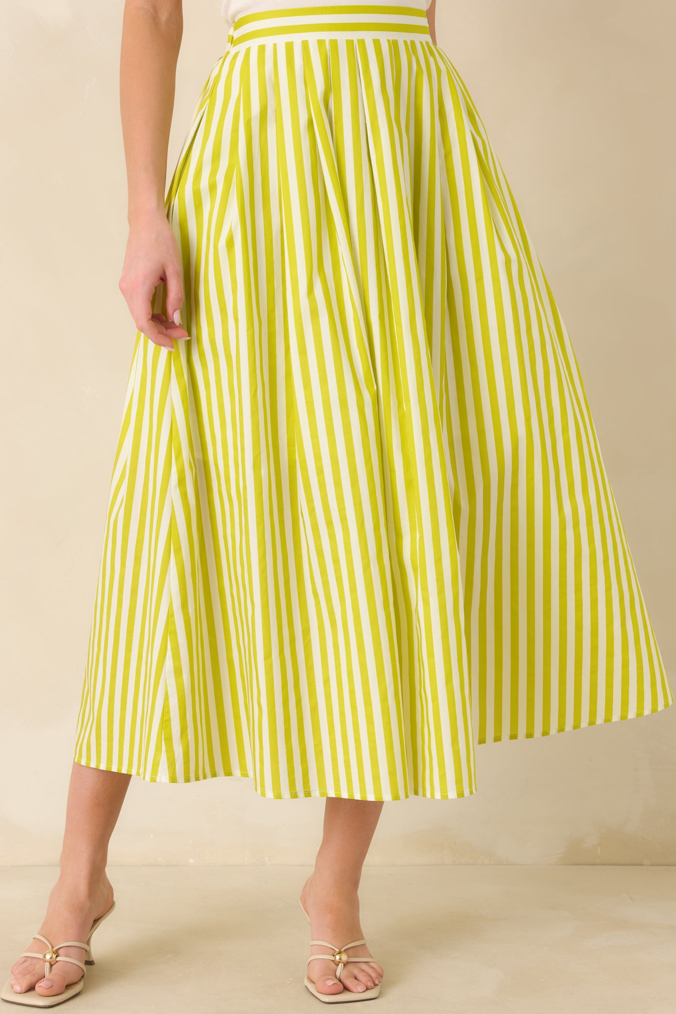  Cropped view showing the volume and soft drape of the green woven cotton skirt fabric.