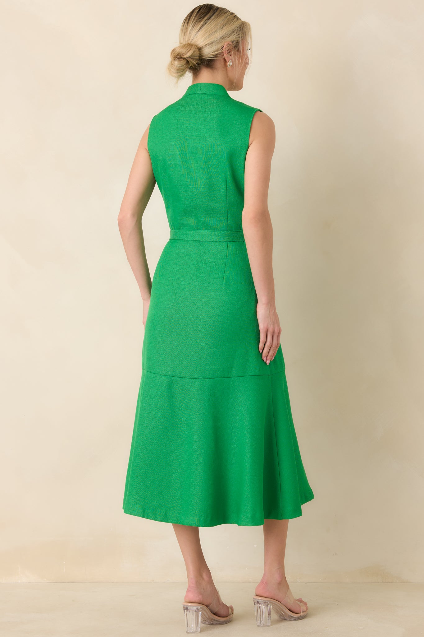 Rear view of the green midi dress featuring clean tailored lines, seam detailing through the bodice, and a softly flared skirt extending from the defined waist.