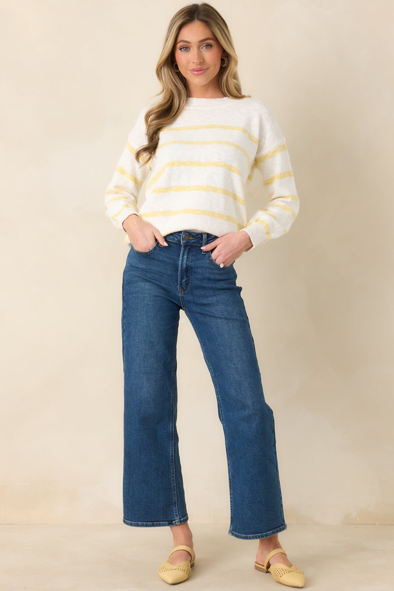 Soft ivory sweater designed with ribbed trim and vibrant yellow striping for a sporty touch.