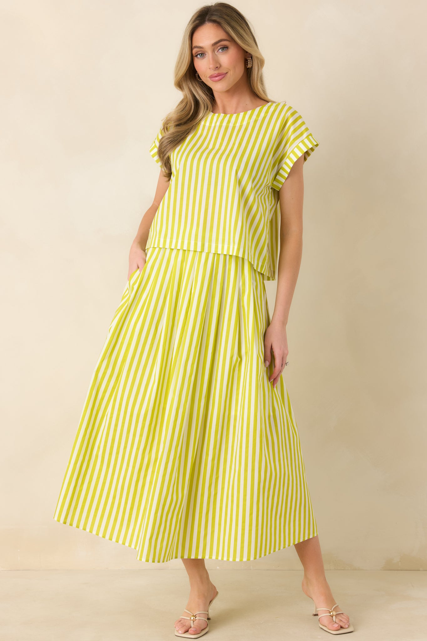 Full-body view showing the green cotton maxi skirt with a structured drape and comfortable elastic waistband.