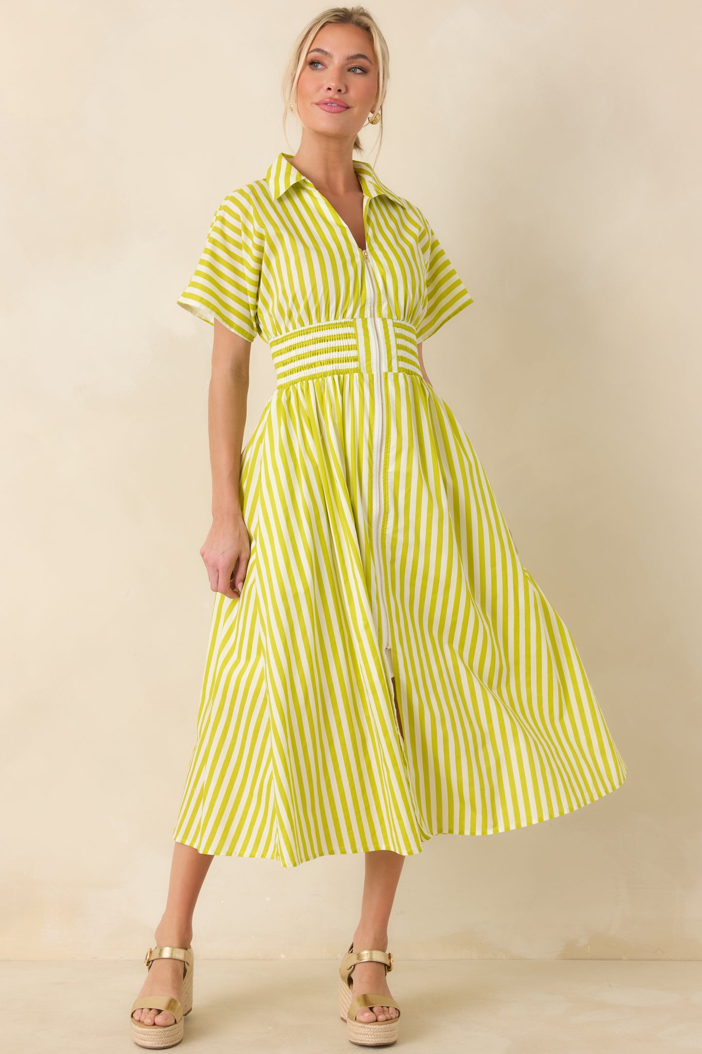 Green and white striped midi dress with a structured collared neckline, zip-front closure, short sleeves, and a wide smocked waistband shaping a full A-line skirt.