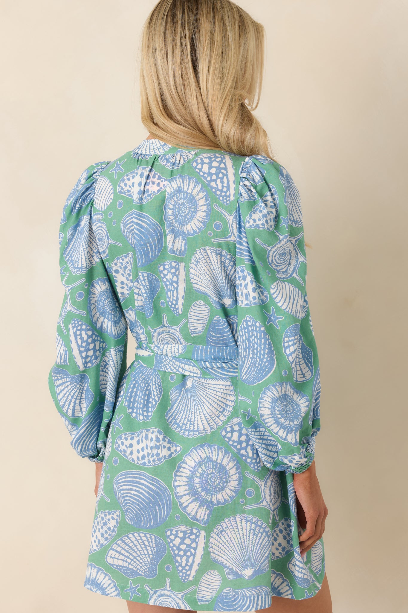 Rear view of green multi mini dress with puff sleeves, relaxed silhouette, and removable self-tie belt.