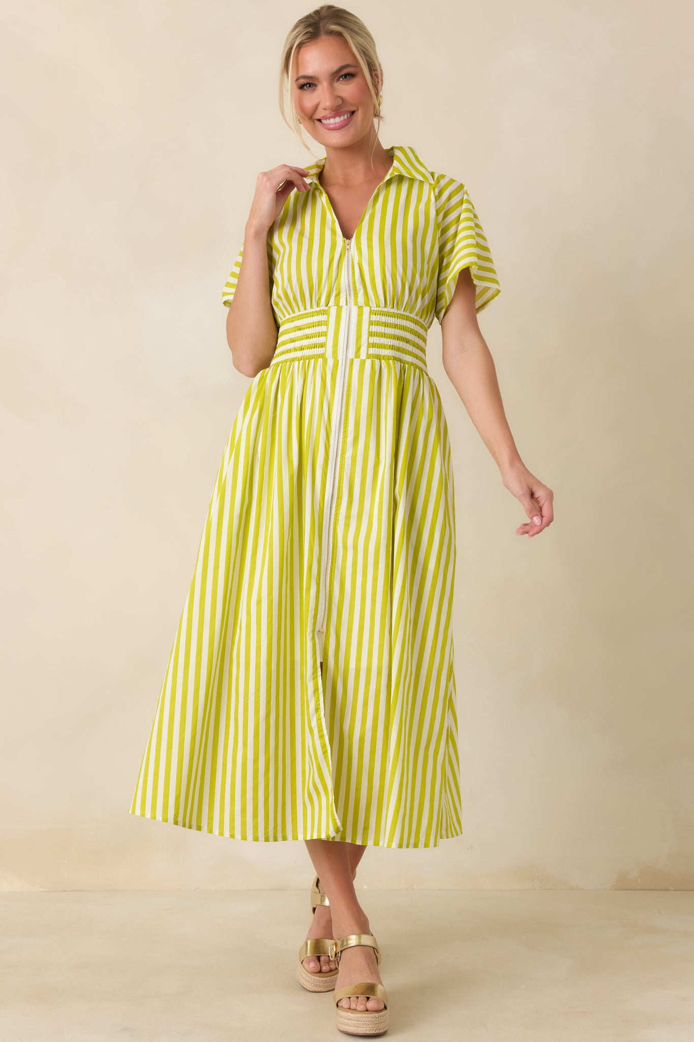 Tailored cotton midi dress featuring vertical green and white stripes, zip-front detail, structured collar, and a flared A-line skirt with comfortable stretch.