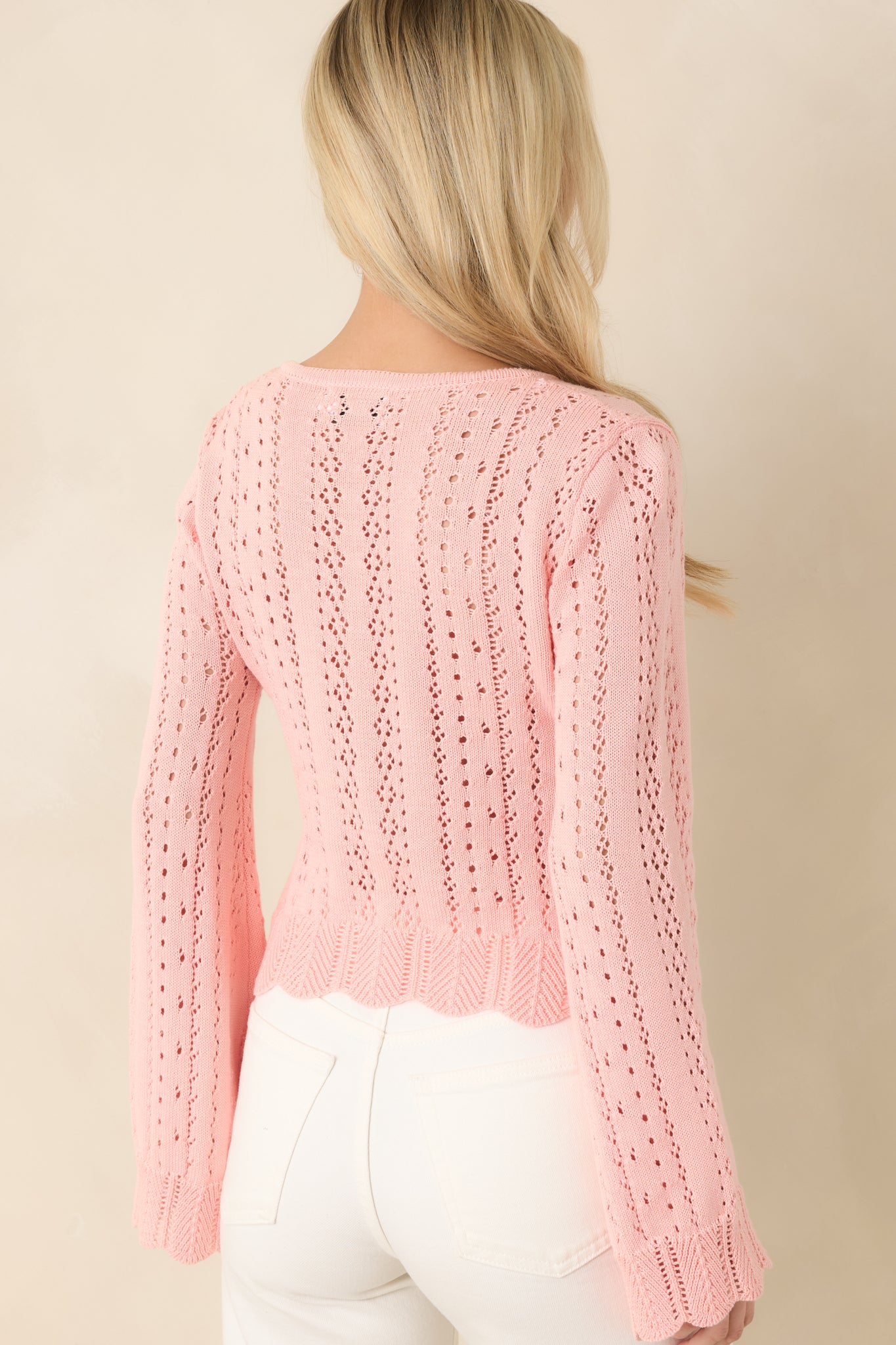 Back view of soft pink cardigan showcasing long sleeves, relaxed fit, and textured pointelle pattern.