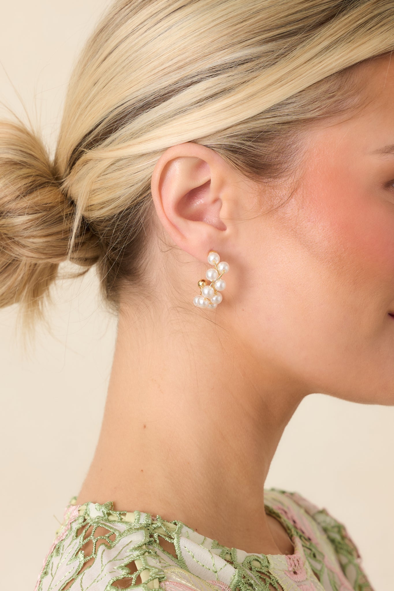 Gold woven hoop earrings featuring delicate wire strands accented with small pearl beads.