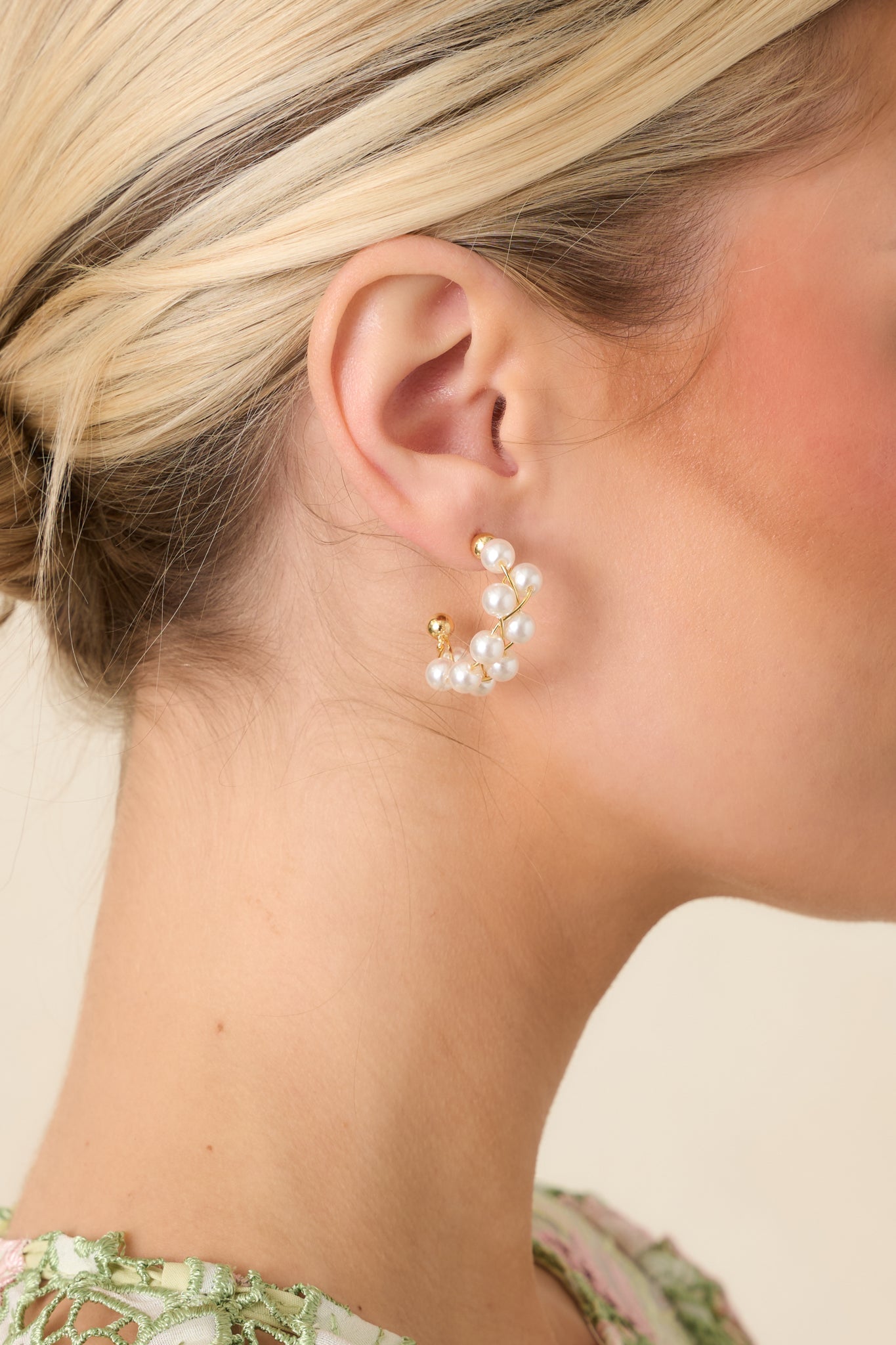 Detailed view highlighting the woven gold wire texture and luminous pearl bead accents along the hoop.