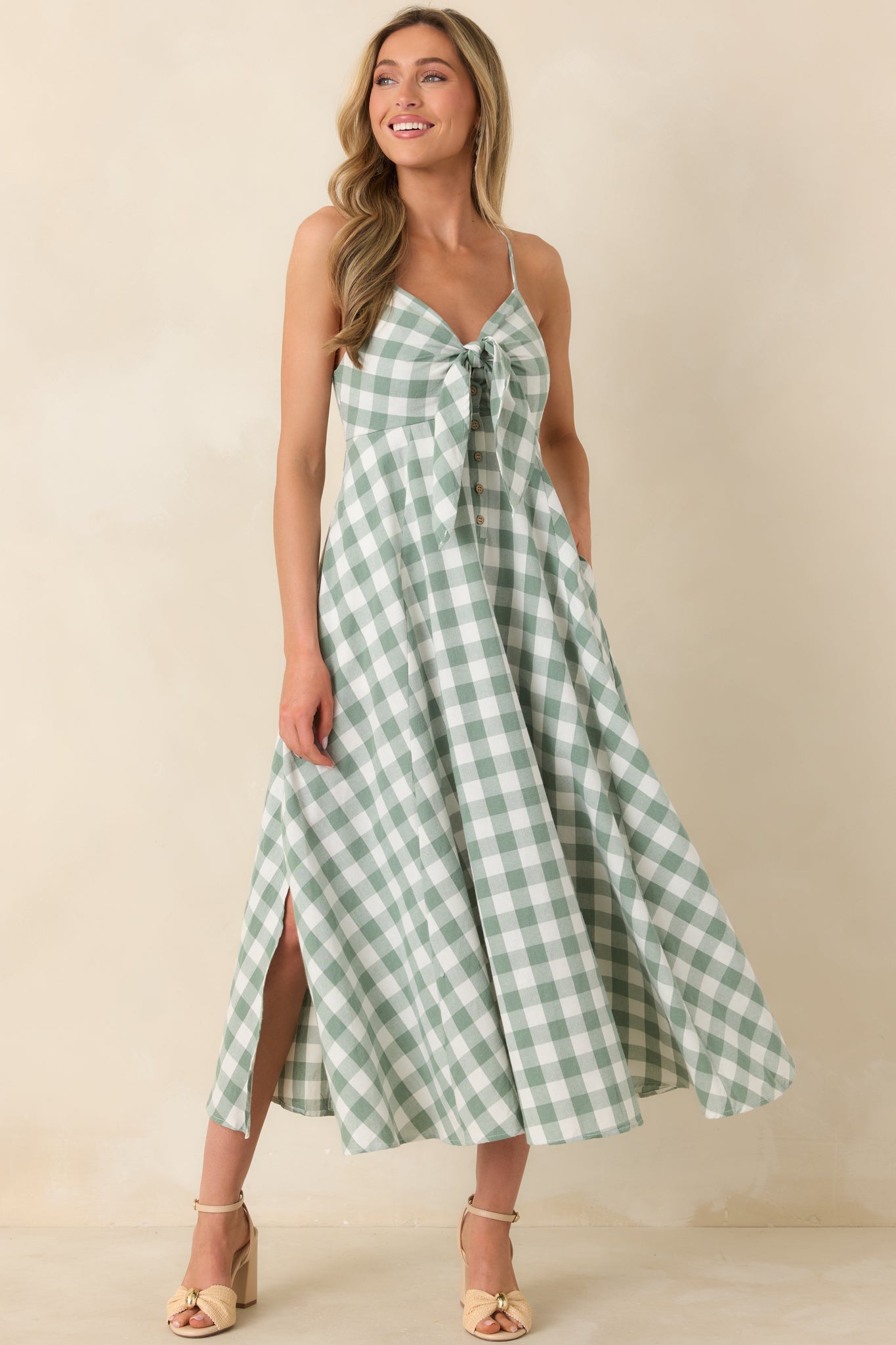 Elegant midi dress showcasing adjustable spaghetti straps, a defined buttoned bodice, and a lightweight skirt that flows naturally with a flattering side slit.