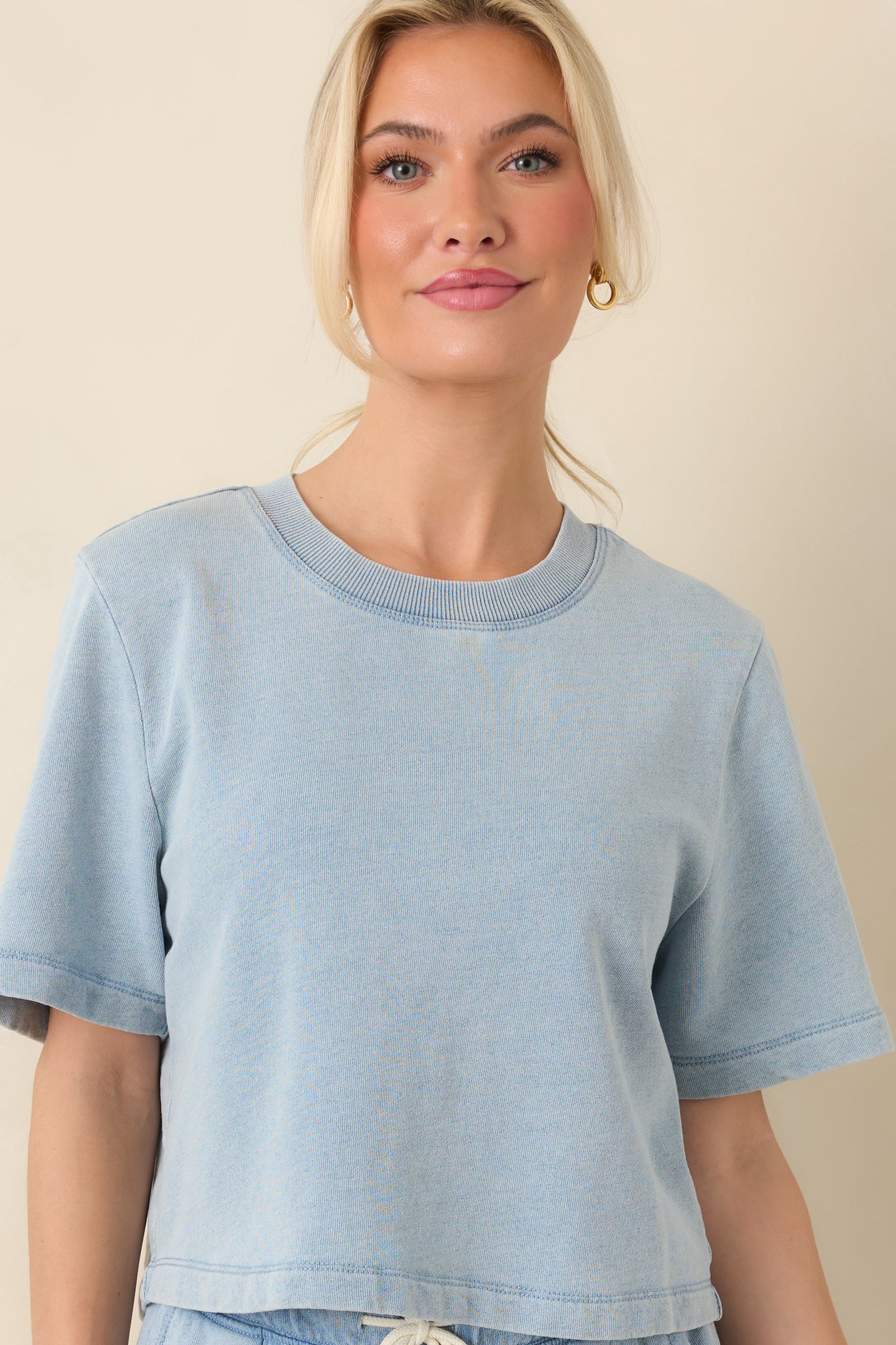 Cropped front view emphasizing the crew neckline and short sleeves of the medium wash sweatshirt.