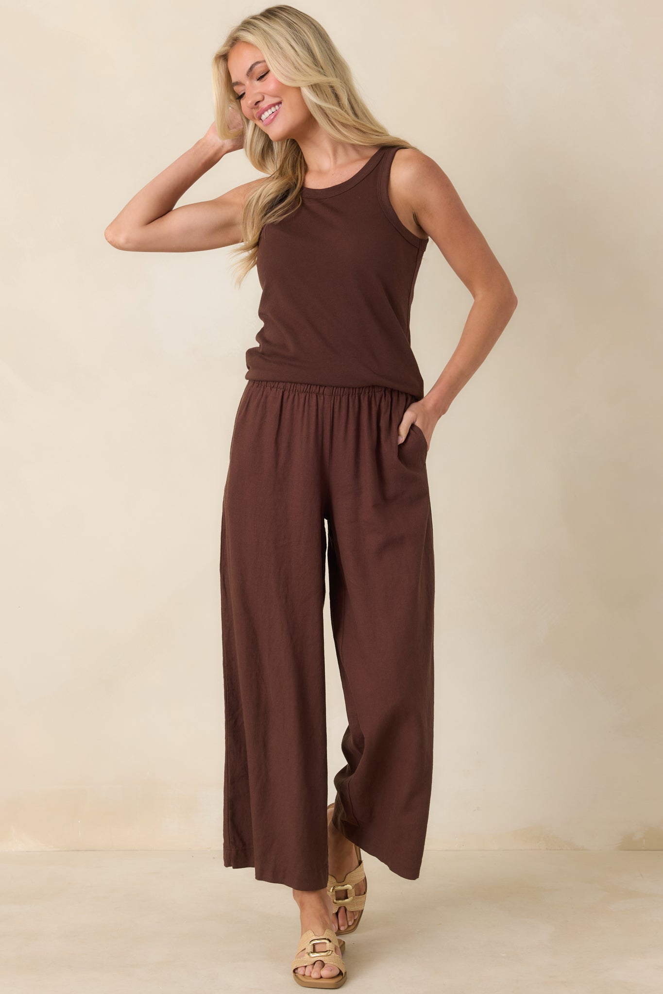 Brown linen pants with relaxed fit, side pockets, and flattering elongated line, shown front-facing.