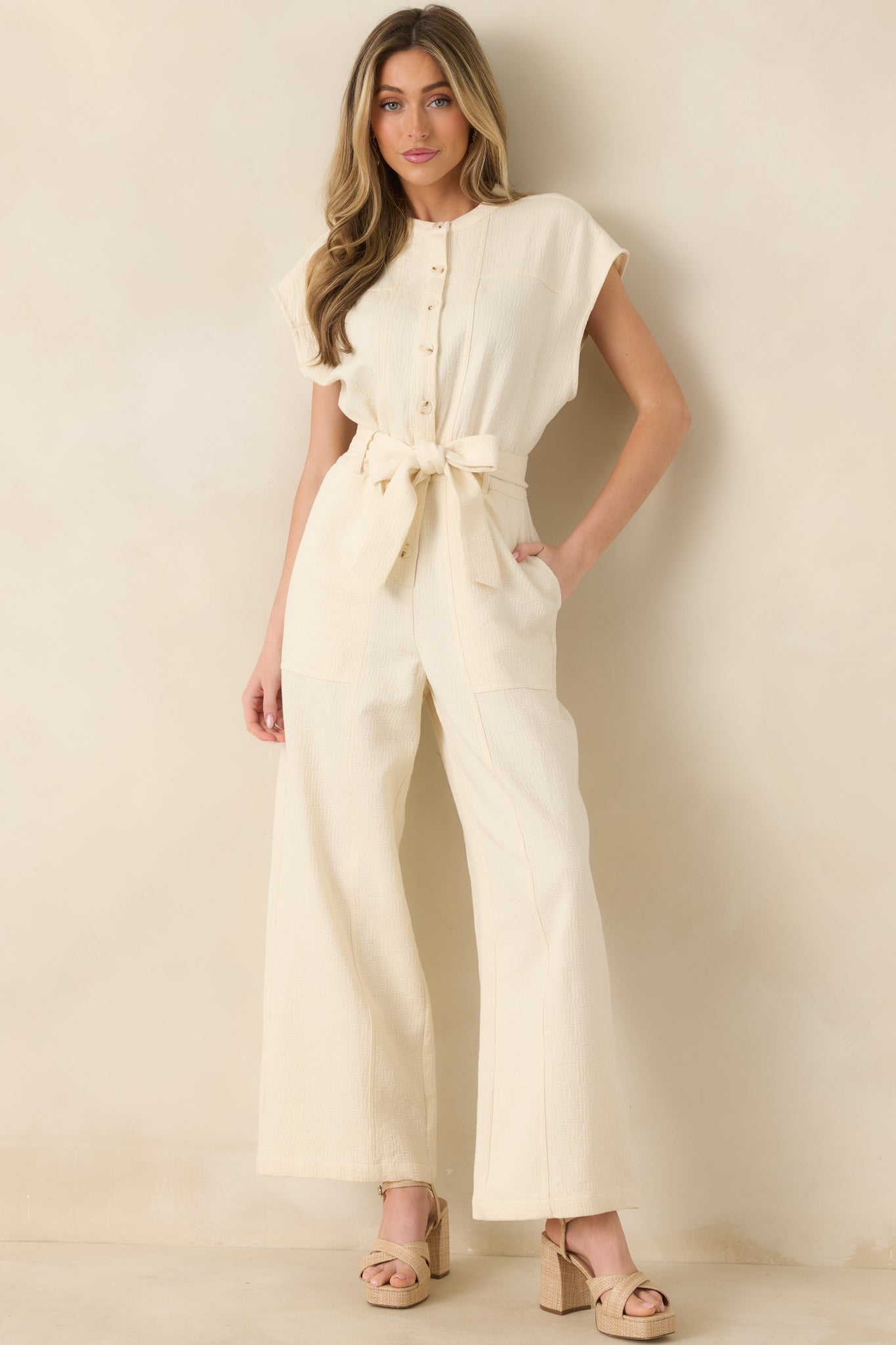 Full-length shot of jumpsuit showcasing relaxed silhouette, clean neckline, and practical side pockets.