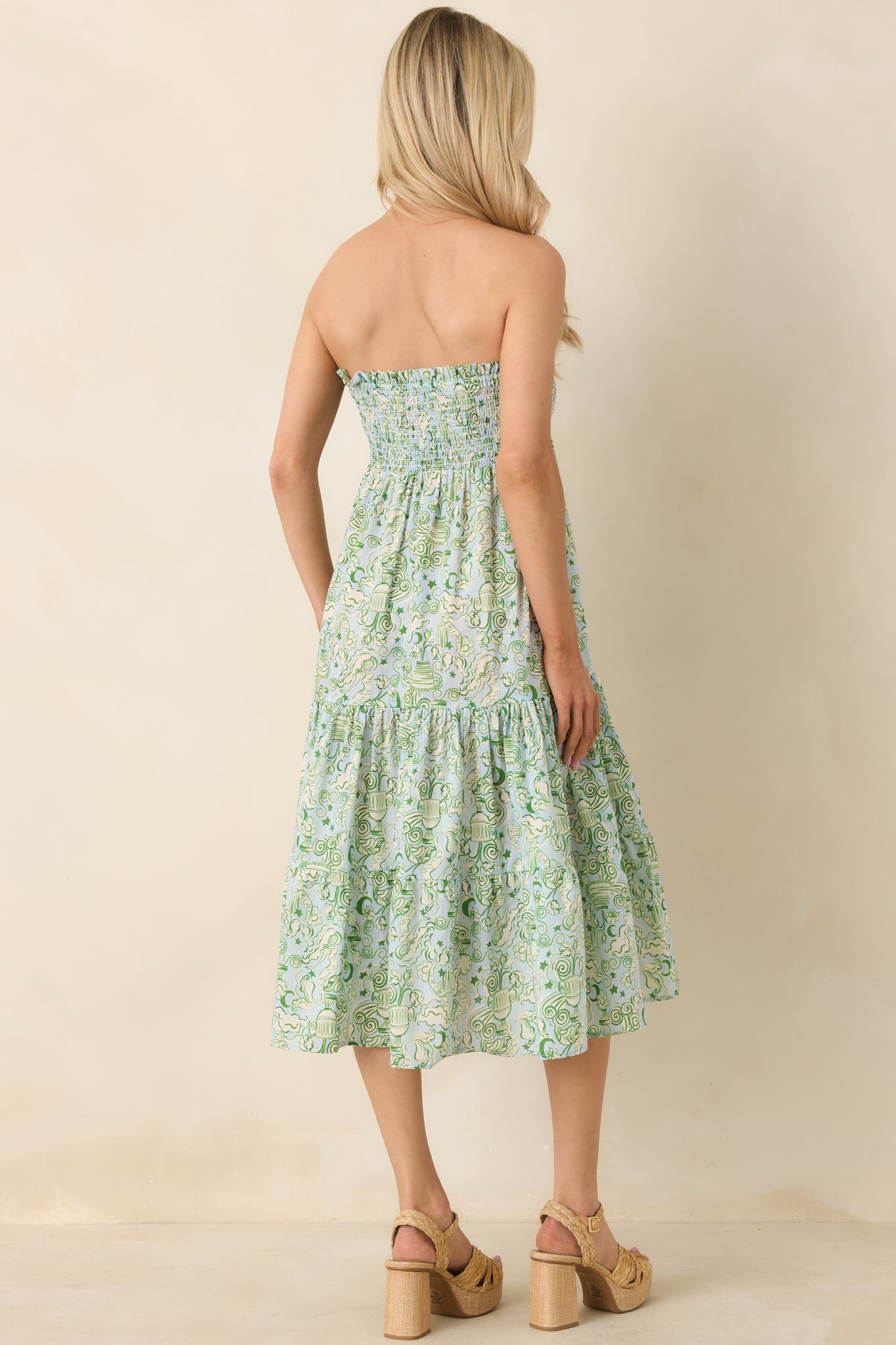 Rear view of strapless blue and green midi dress with smocked panel and gently draped skirt.