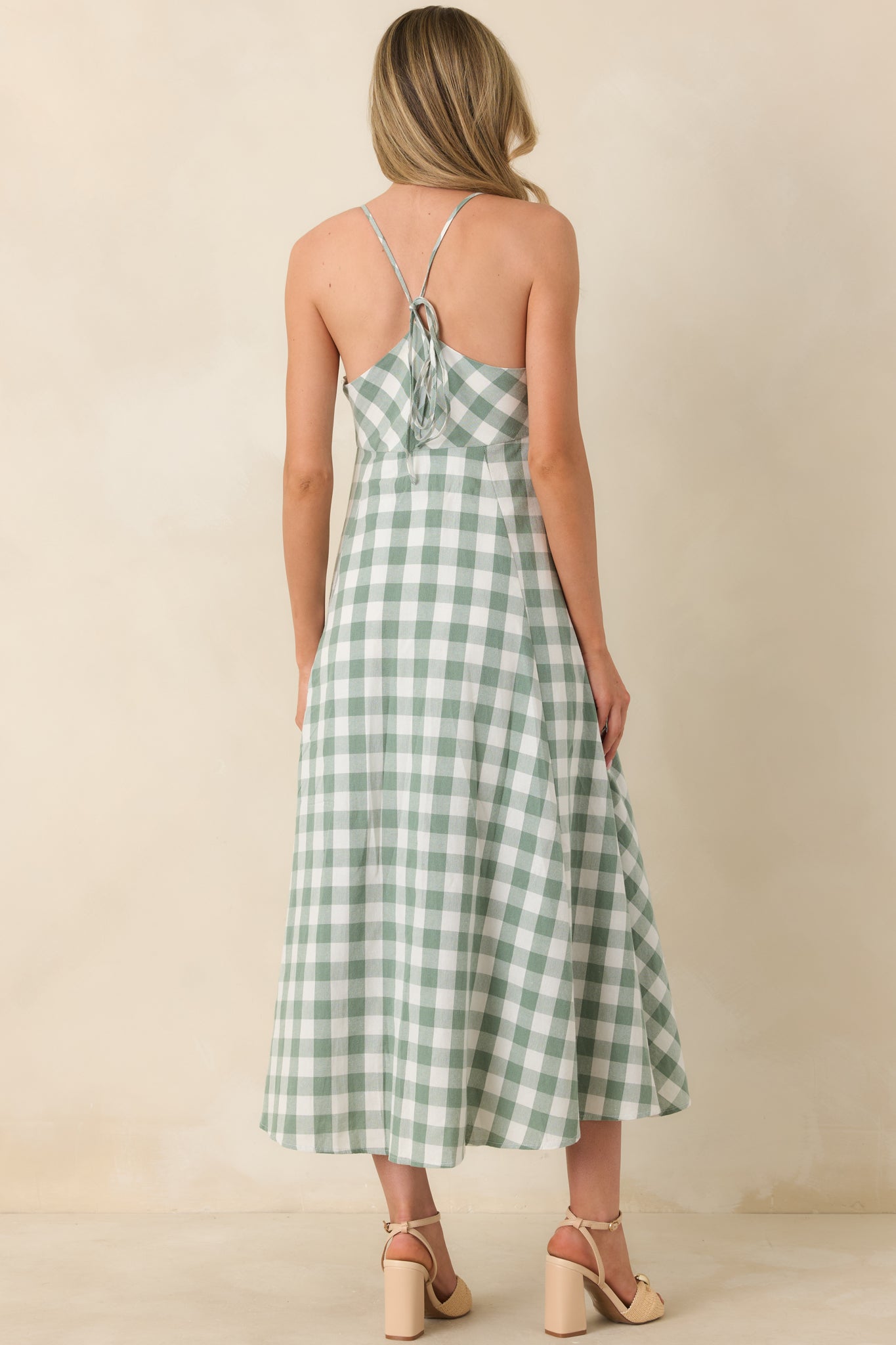 Rear view reveals the lace-up back design with adjustable spaghetti straps, creating a customizable fit and adding a romantic finishing touch to the flowing midi silhouette.