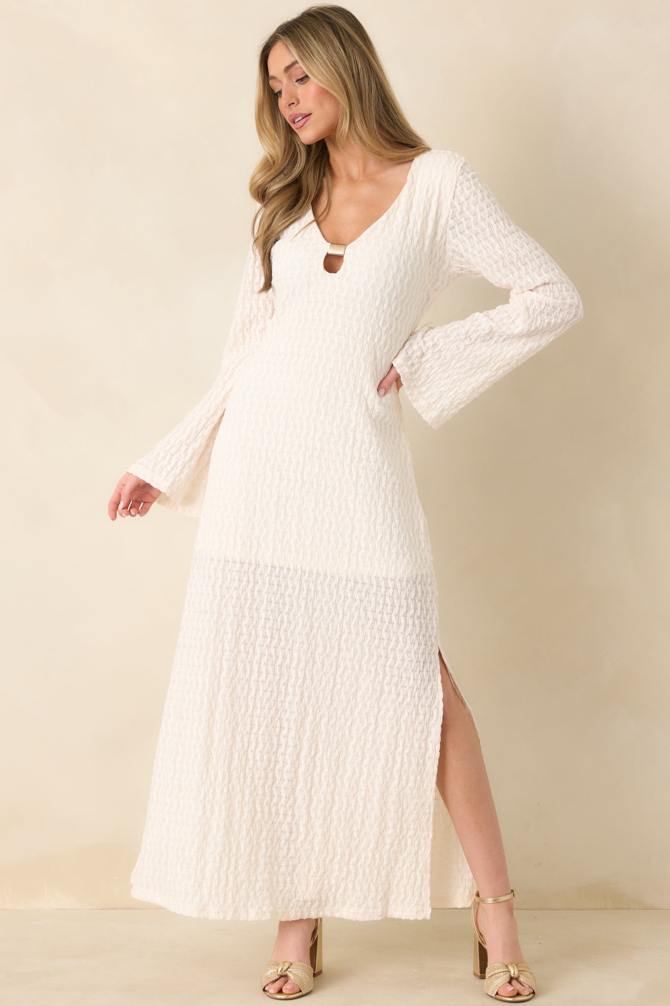 Semi-sheer maxi dress with long sleeves, side slits, and fluid movement.