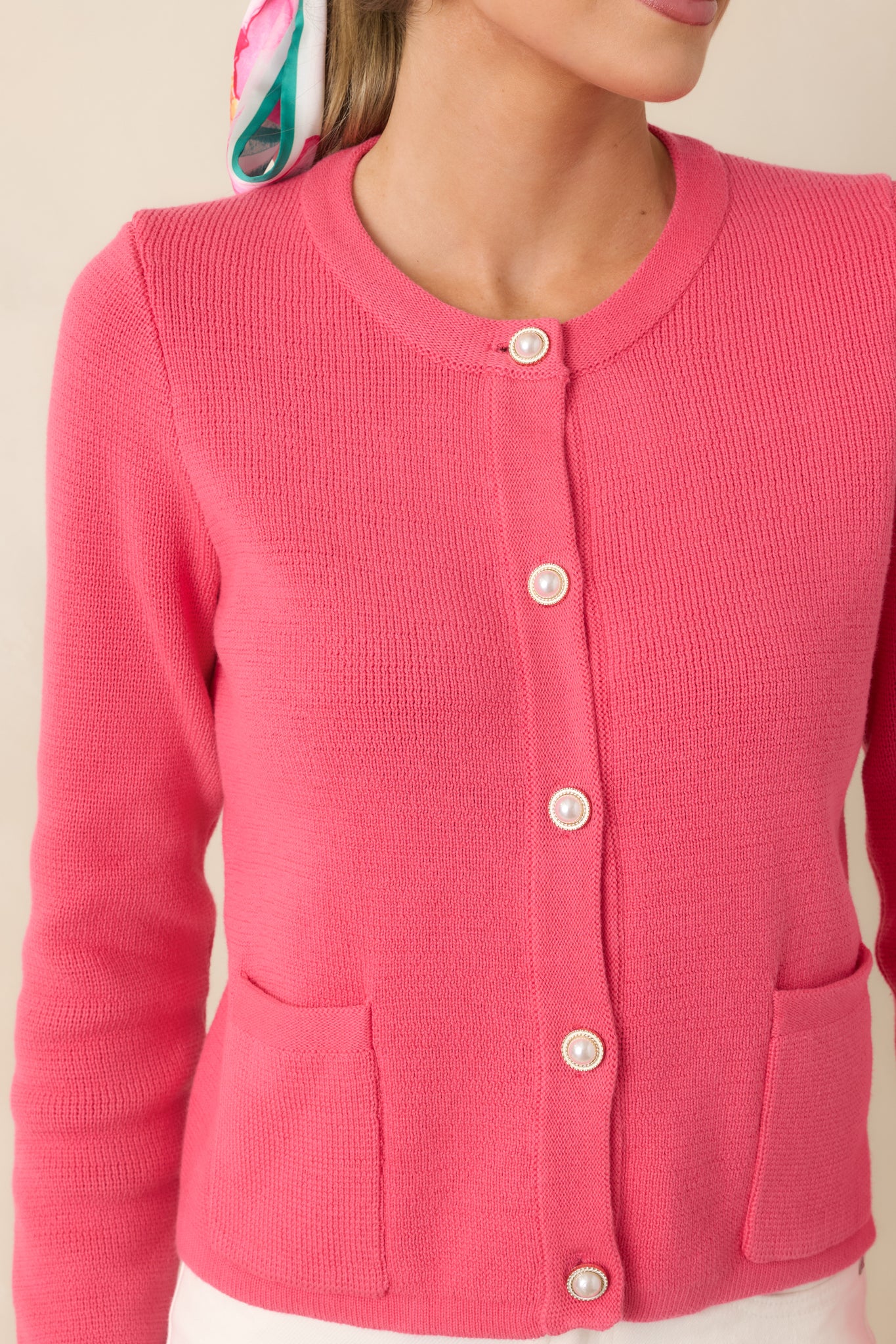 Cropped view of the cotton cardigan showcasing pearl-style buttons and the subtle texture of the knit fabric.