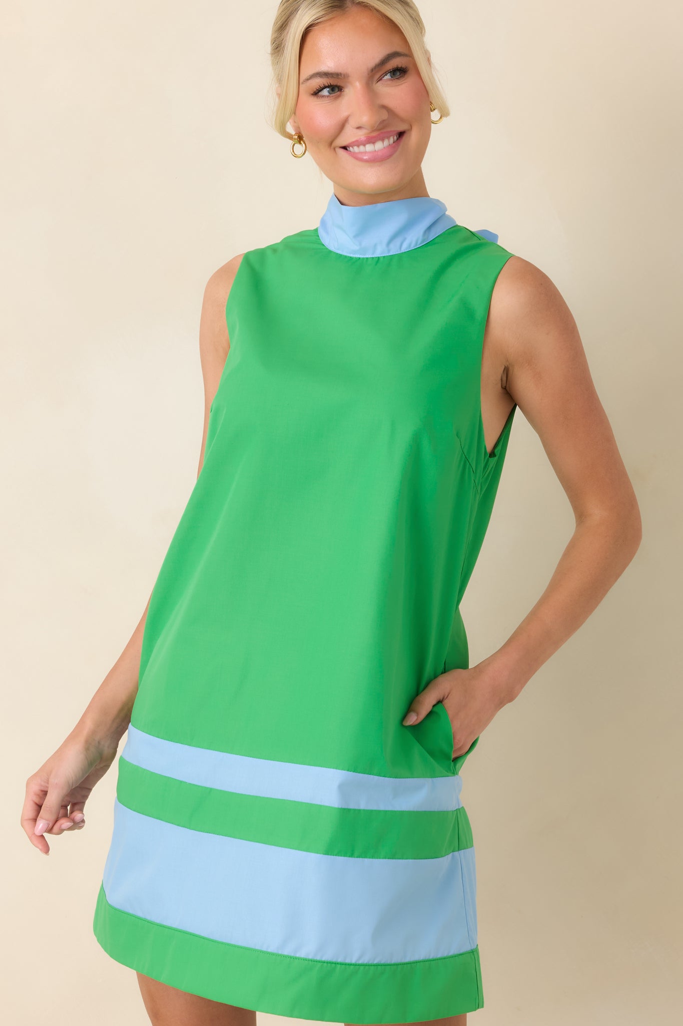Clean-lined sleeveless mini featuring a contrast banded hem and gently draping silhouette for effortless modern styling.