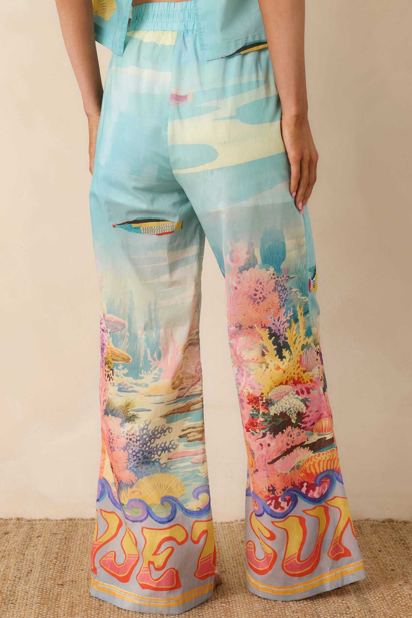 Rear view of the wide-leg pants with elastic waistband and colorful tropical reef print.