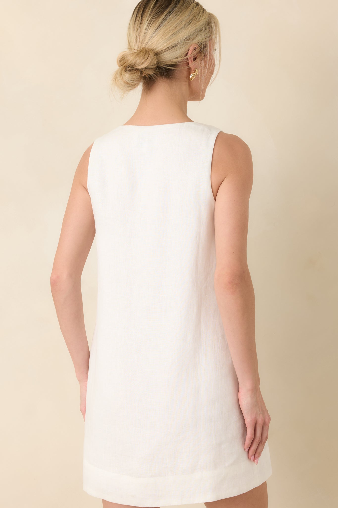 Rear view of white sleeveless mini dress with clean, relaxed shift shape