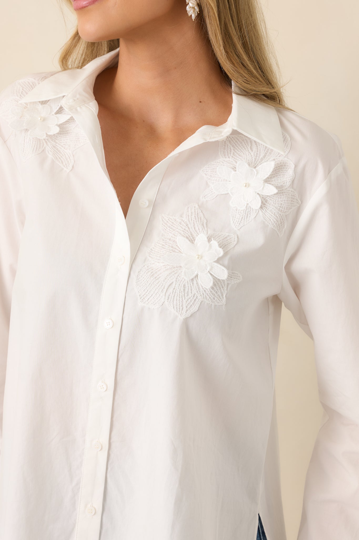 Close-up of the floral appliqué details, lightweight woven texture, and precise button-down construction.
