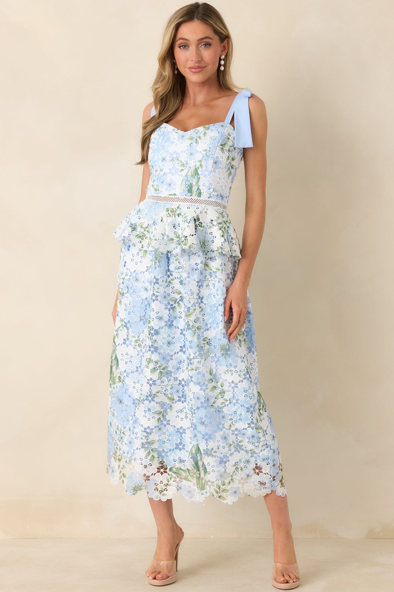 Light blue floral lace midi dress with V-neckline, self-tie straps, and ruffle detailing at the waist.
