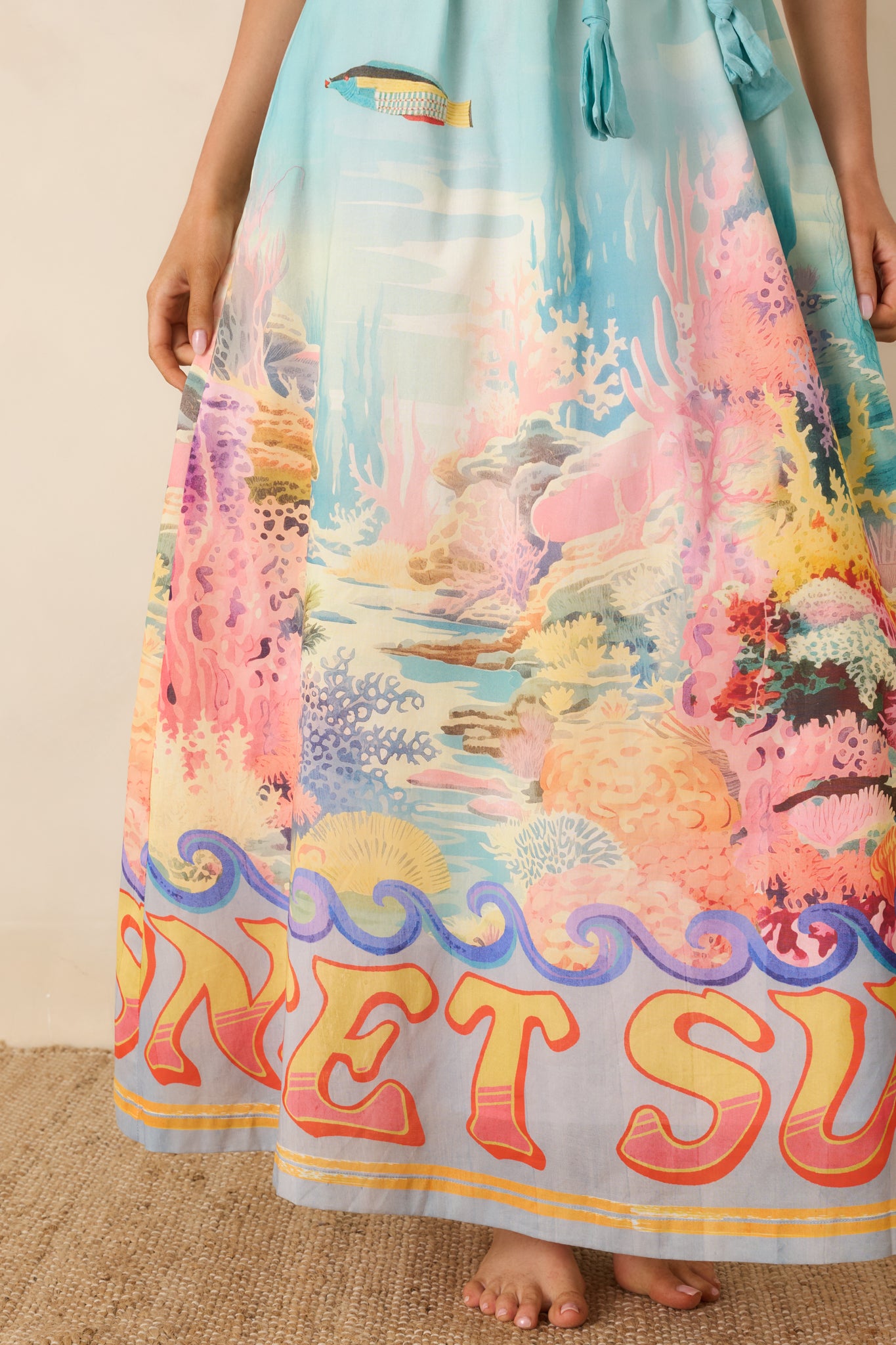 Detailed view of the colorful reef print, coral tones, and ocean-inspired motifs on the skirt.