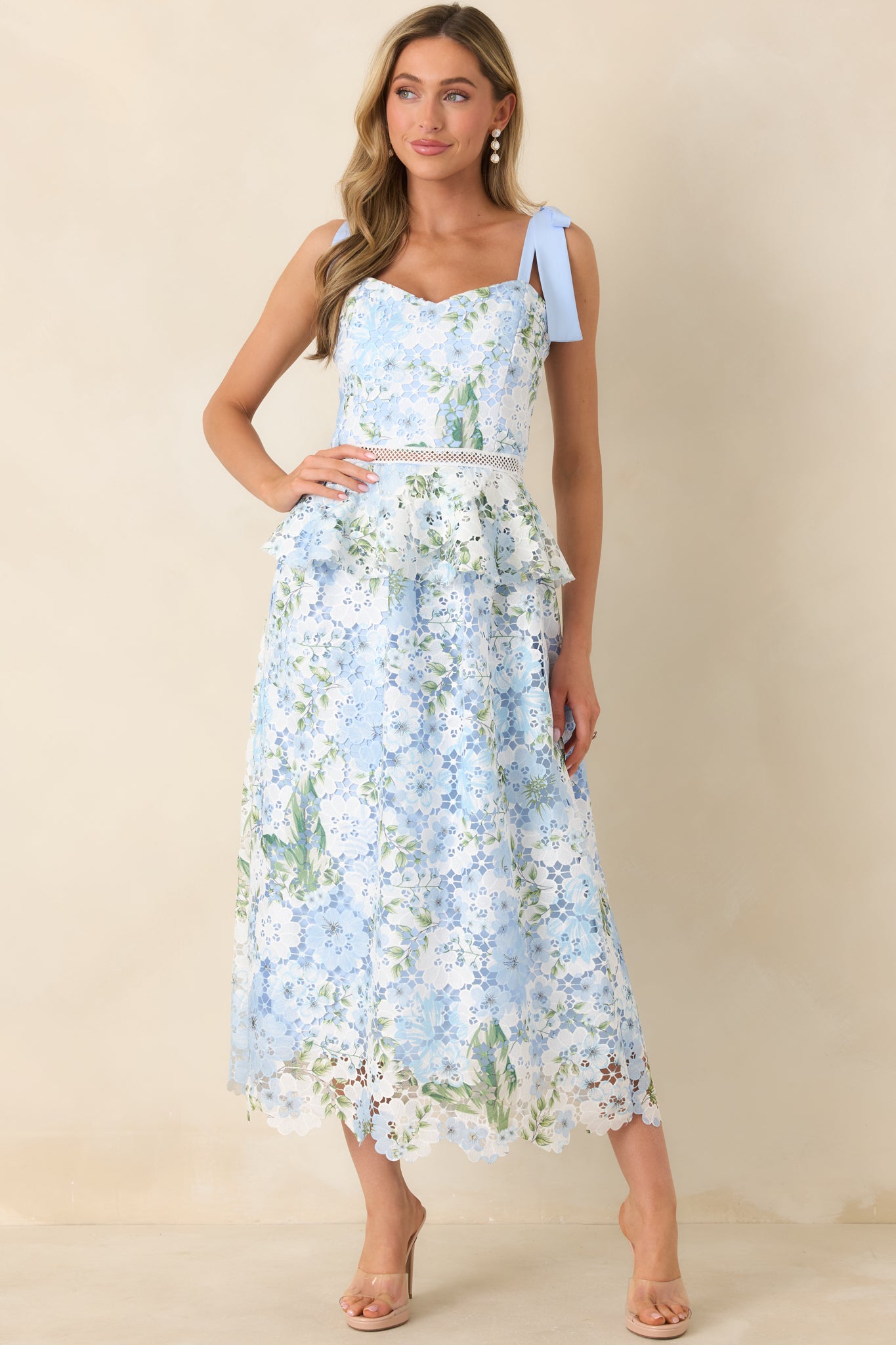 Romantic light blue midi dress featuring knitted lace overlay, delicate floral print, and flowing skirt.