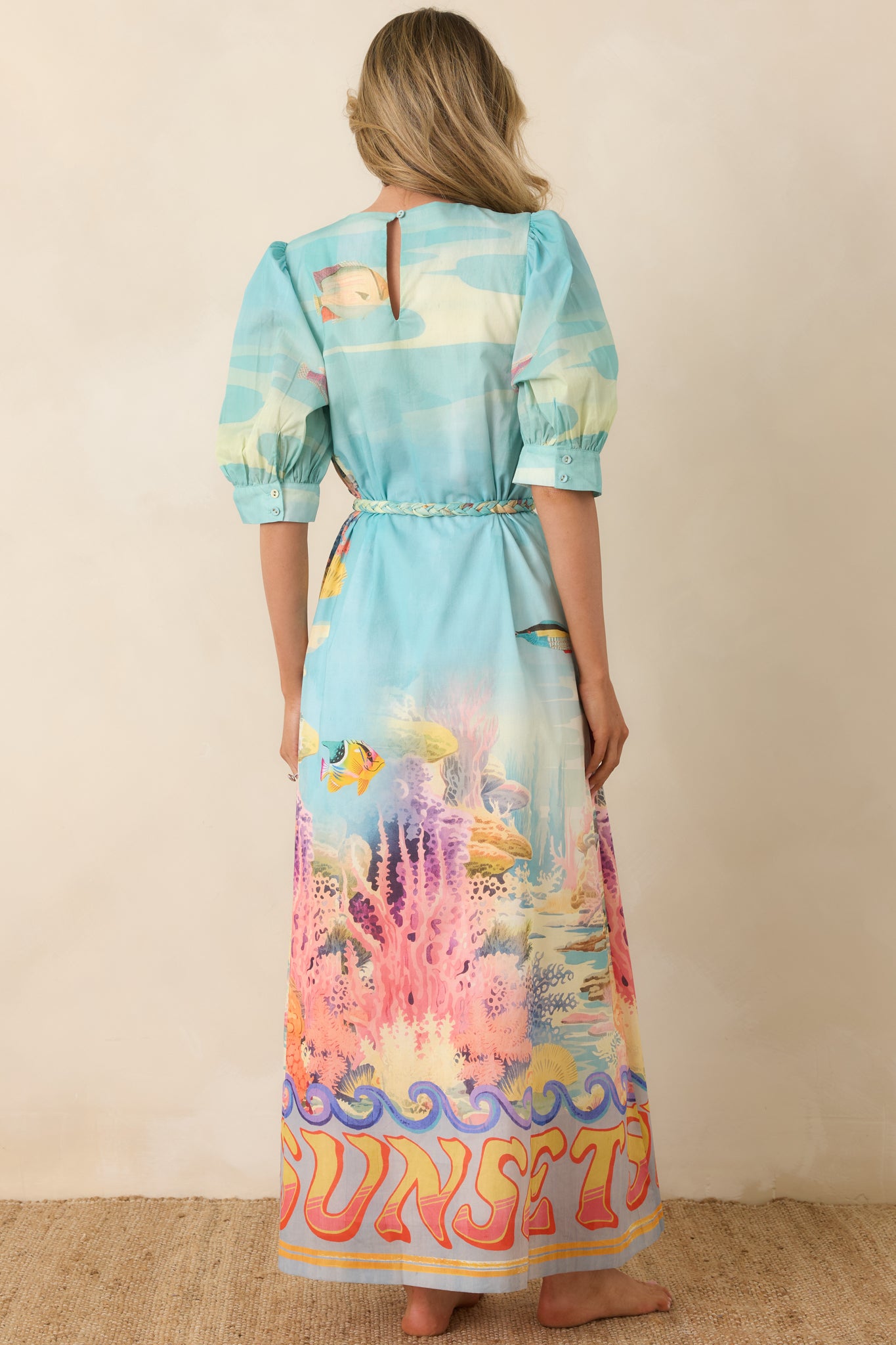 Rear view of the breezy maxi dress with puffed sleeves and adjustable tie waist.